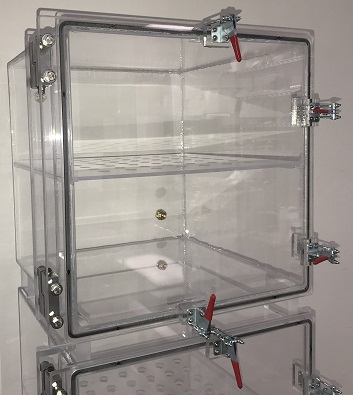 two desiccator cabinets with perforated shelf
